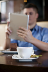 Young man using tablet in coffee shop