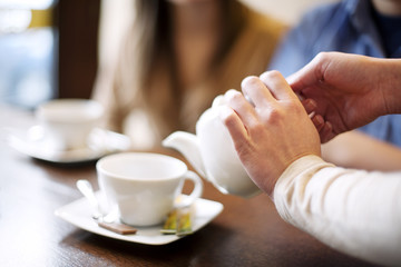Waitress pouring cup of coffee/tea
