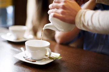 Photo sur Aluminium Restaurant Waitress pouring cup of coffee/tea