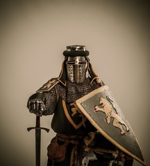 Kneeled medieval knight with sword and shield