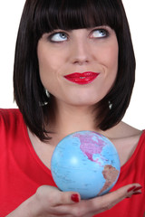 Woman in red holding planet earth