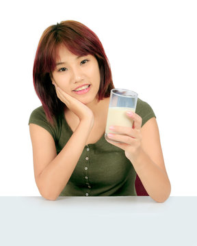 Isolated young asian woman with a glass of milk