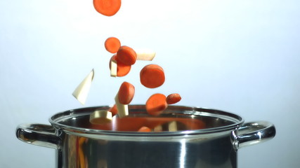 Chopped carrot and parsnip falling into saucepan - Powered by Adobe