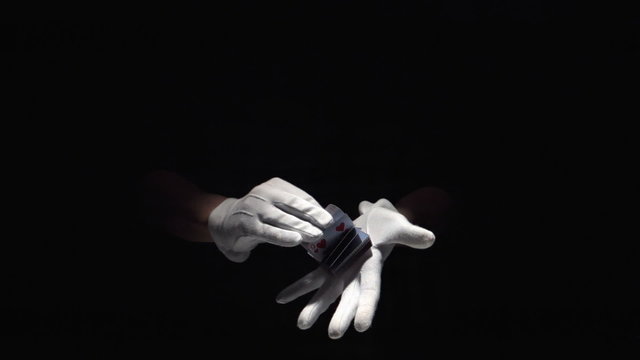 Gloved hands flicking through deck of cards