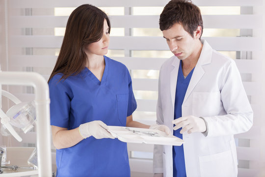 Dentist and assistant choosing the right instrument