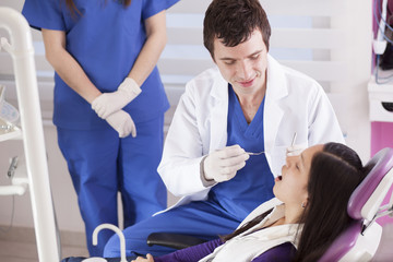 Young male dentist working on a teenage patient