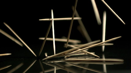 Toothpicks falling on black background - Powered by Adobe