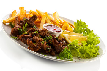 Grilled meat with French fries and vegetables