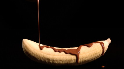 Melted chocolate pouring over a banana - Powered by Adobe