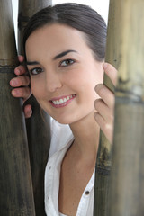Fototapeta premium Woman stood amongst wooden poles