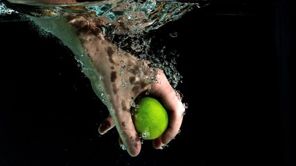 Hand grabbing lime from water in slow motion - Powered by Adobe