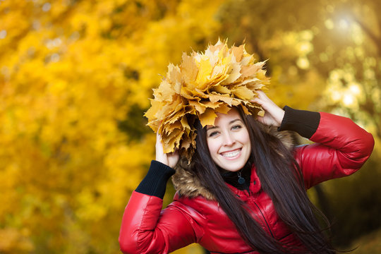 happy  woman in a wreath of yellow autumn leaves