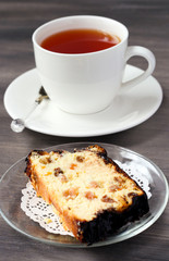 Slice of cheesecake with raisin and candied peel and cup of tea