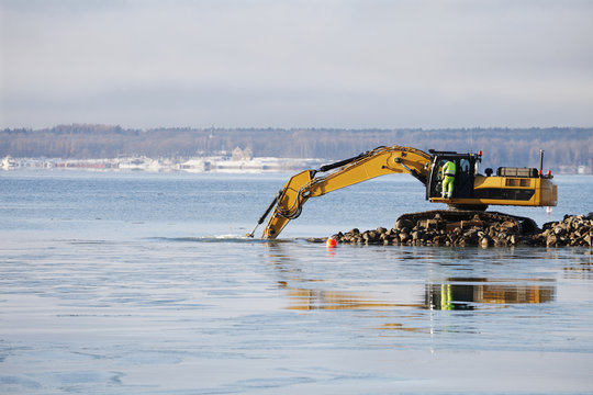 bulldozer doing dredging works in icy sea