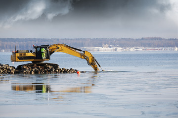 bulldozer and driver dredging in the sea