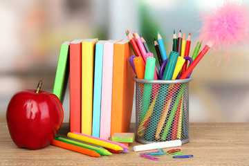 School supplies with apple on wooden table