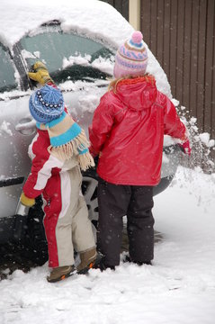 Kinder befreien Auto von Eis und Schnee
