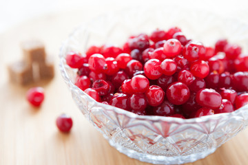 cranberries in a transparent bowl and refined sugar