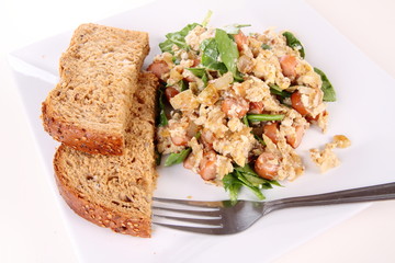 Scrambled eggs with frankfurters and spinach