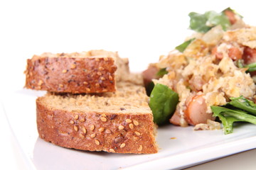 Scrambled eggs with frankfurters and spinach, and a fork