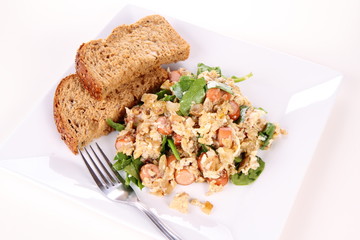 Scrambled eggs with frankfurters and spinach