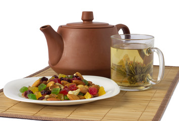 teacup with teapot and candied fruits isolated