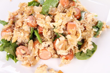 Scrambled eggs with frankfurters and spinach, and a fork