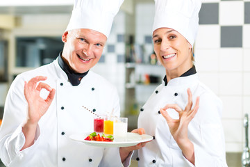 Chef team in restaurant kitchen with dessert