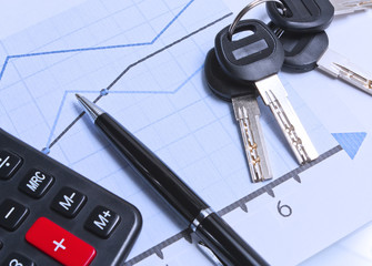 Financial charts and a bunch of keys on the table