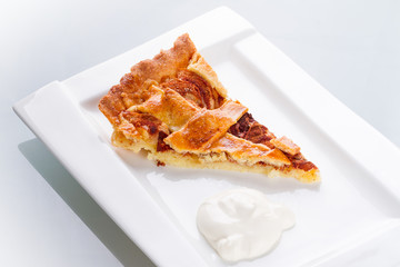 Piece of apple tart and cream on the plate