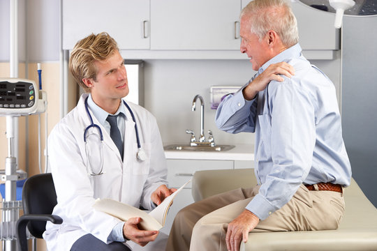 Doctor Examining Male Patient With Shoulder Pain
