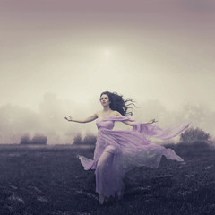 Portrait of woman running over the field