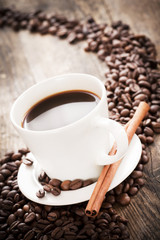 Coffee tastefully presented, next to coffee beans.