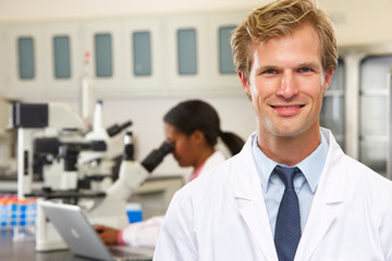 Obraz premium Male And Female Scientists Using Microscopes In Laboratory