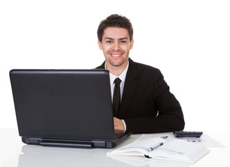Smiling businessman seated at his desk
