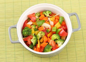 Vegetable stew in gray pot on bamboo mat background