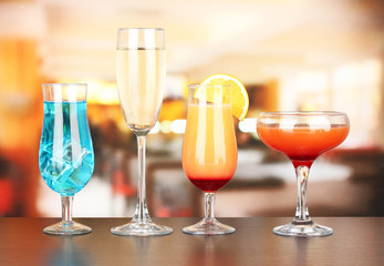 Several glasses of different drinks on bright background
