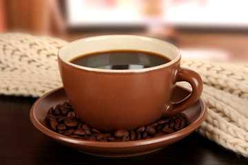 cup of coffee with scarf on table in room