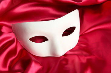 White mask, on red silk fabric