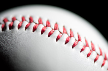 Macro shot of a baseball over black background, shallow DOF
