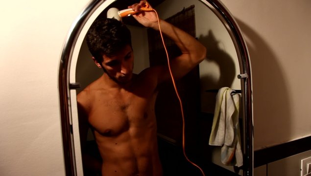 ragazzo asciuga i capelli in bagno di sera