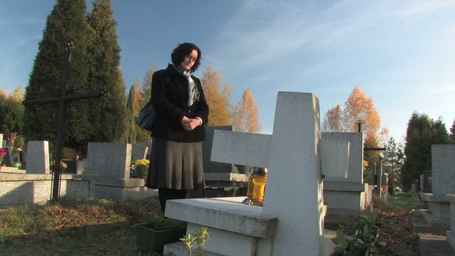 widow praying at a grave
