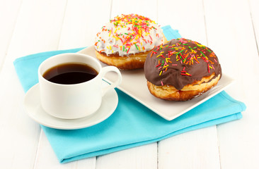 Tasty donuts on color plate on light wooden background