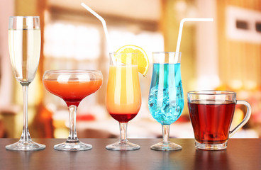Several glasses of different drinks on bright background