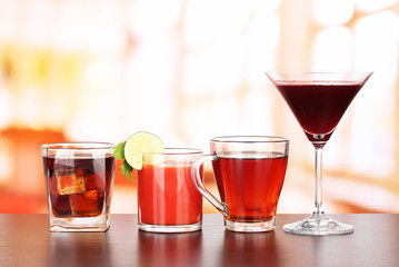 Several glasses of different drinks on bright background