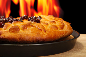 tasty homemade pie with jam, on wooden table on flame