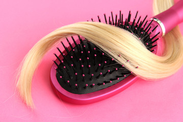 Comb brush with hair,  on pink background