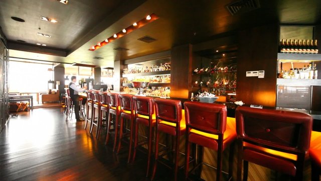 Many chairs stands along bar counter