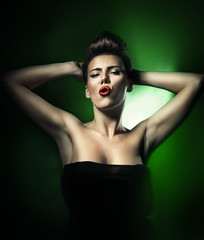Naklejka premium hot beautiful woman with red lips in dark green light