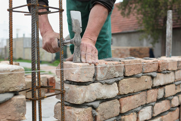 Mason making wall with mortar and bricks